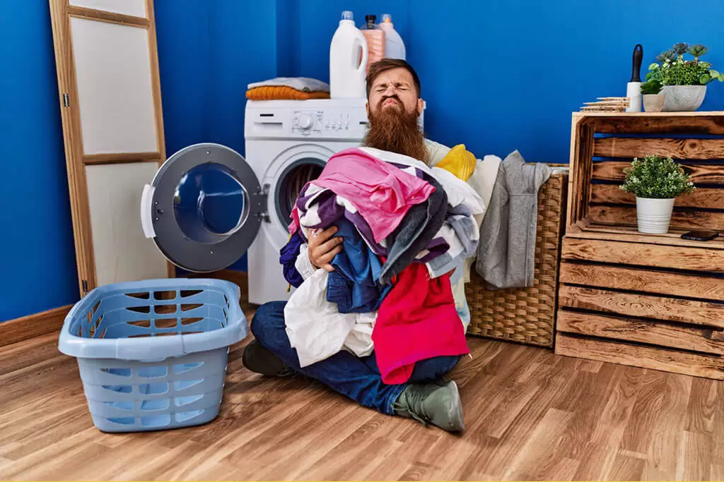 Чоловік з купой одягу для прання в пральні "Прищіпка"